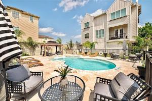 eine Terrasse mit einem Tisch und Stühlen sowie einem Pool in der Unterkunft Townhouse in Houston in Houston