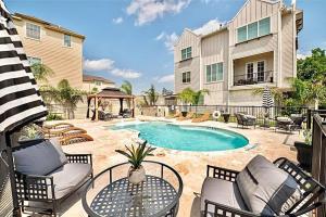 um pátio com uma mesa e cadeiras e uma piscina em Townhouse in Houston em Houston