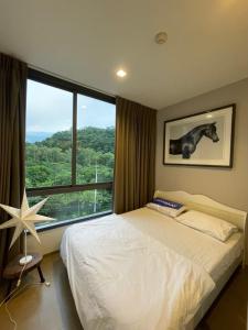 a bedroom with a bed and a large window at The Valley by Pook46 in Nakhon Ratchasima