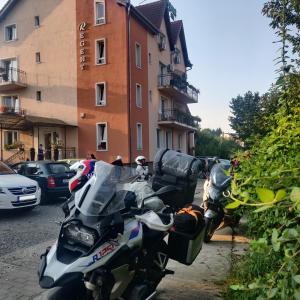 un groupe de motocycles garés devant un bâtiment dans l'établissement Regent Garden, à Băile Felix