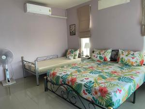 168Hostel Airport@Phuket في تالانغ: غرفة نوم بها سرير وسرير ومروحة