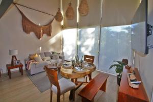 a living room with a table and a couch at Luxury Jungle Loft, 7 Pools, Rooftop Panoramic View, Beach Shuttle, Fast WiFi in Tulum