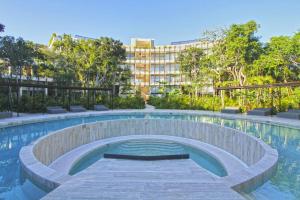 a swimming pool with a building in the background at Luxury Jungle Loft, 7 Pools, Rooftop Panoramic View, Beach Shuttle, Fast WiFi in Tulum