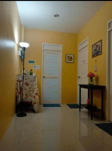 a room with yellow walls and a table and a door at 168Hostel Airport@Phuket in Thalang