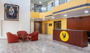 a lobby with two chairs and a reception desk at Treebo Trend Y Hotels Elite - Jagamara in Bhubaneshwar