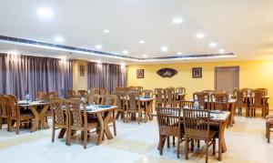a restaurant with tables and chairs in a room at Treebo Trend Y Hotels Elite - Jagamara in Bhubaneshwar