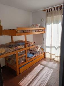 een kamer met 3 stapelbedden en een raam bij Apartamento estilo marinero en Calella Palafrugell in Palafrugell