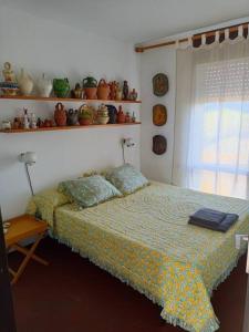 een slaapkamer met een bed en een raam en planken bij Apartamento estilo marinero en Calella Palafrugell in Palafrugell