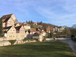 a group of buildings on a hill next to a river at Ferienwohnung Am Stadtpark in Schwäbisch Hall