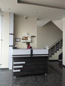 a man standing behind a counter in a building at Knights Inn in Shamshi