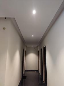 an empty hallway with white walls and a ceiling at Knights Inn in Shamshi