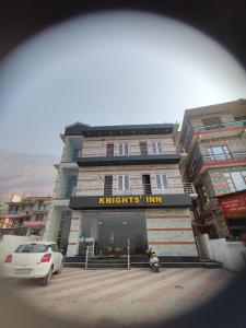 a building with a car parked in front of it at Knights Inn in Shamshi