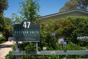 a sign in front of a house with flowers at Basedow Units Tanunda in Tanunda