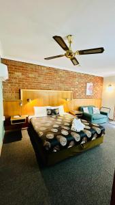 a bedroom with a large bed and a ceiling fan at Early Australian Motor Inn in Mildura