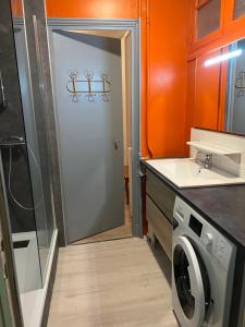 uma cozinha com uma porta e uma máquina de lavar roupa em La Résidence 1 em Le Mont-Dore