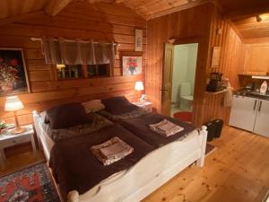 a bedroom with a large bed in a wooden room at Timrad stuga i kanten av skogen med SPA möjlighet in Mullsjö