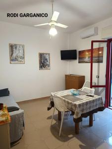 Zimmer mit einem Tisch, einem Bett und einem TV in der Unterkunft Marechiaro in Foce Varano