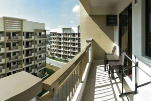 Un balcón con una silla y algunos edificios de apartamentos. en Asteria Residences Annabel CozyPlace highspeed wifi, en Manila