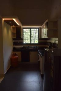 una pequeña cocina con fregadero y ventana en Home with garden in a serene locality, en Wayanad