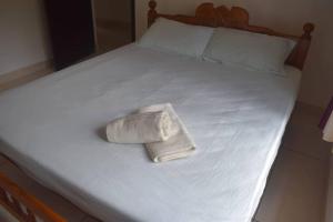 a white towel sitting on top of a bed at Home with garden in a serene locality in Wayanad