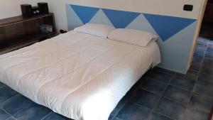 un grande letto bianco con testiera blu in una stanza di Belvedere Bronte 01 e Belvedere Bronte 02 a Bronte