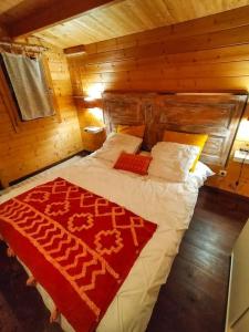 ein Schlafzimmer mit einem großen Bett in einem Holzzimmer in der Unterkunft le chalet sous l'olivier in Boulbon