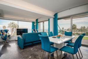 uma sala de estar com uma mesa e cadeiras azuis em Protaras Beachfront Thalassa Suite em Protaras