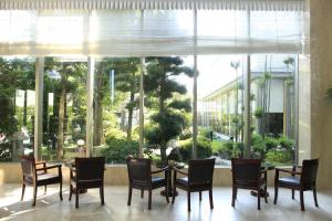 een eetkamer met een tafel en stoelen en een groot raam bij Bellevue Garden Hotel Kansai International Airport in Izumi-Sano