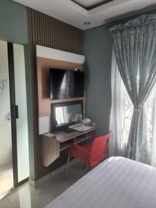 a bedroom with a desk and a red chair at Josmot Guest House in Gaborone
