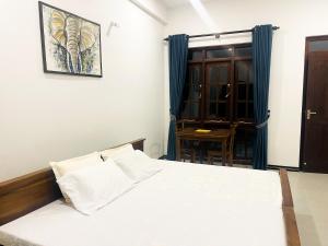 a bedroom with a white bed and a table at Victoria Nature Resort in Digana