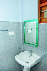 a bathroom with a sink and a mirror at Randu Homestay and Restaurant in Tangalle