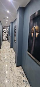einen Flur mit blauen Wänden und einem Gemälde an der Wand in der Unterkunft Blu room in Taranto