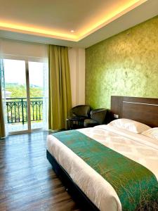 a hotel room with a bed and a balcony at Malibest Resort in Pantai Cenang