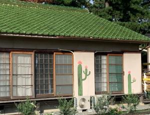 Una casa con cactus pintados a un lado. en Kanzaki Beach House 