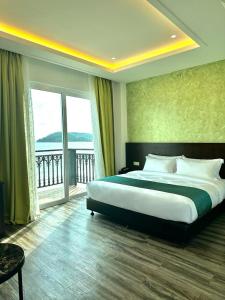 a bedroom with a large bed and a large window at Malibest Resort in Pantai Cenang