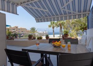 einen Tisch mit zwei Gläsern Wein und eine Schale Obst in der Unterkunft 105 Kings Palace - Fabulous 2 Bed, 2 bath, Large Patio with Garden - Sea Views in Paphos City