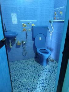 a bathroom with a blue toilet and a fish tank at Seashell in Madgaon