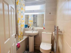 een badkamer met een toilet, een wastafel en een raam bij Entire 2 beds terrace house near Ricoh Arena. in Coventry