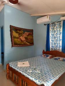 1 dormitorio con 1 cama con una pintura en la pared en Seashell, en Margao