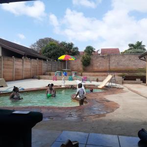 a group of people playing in a swimming pool at Kwesethu Guesthouse in Empangeni