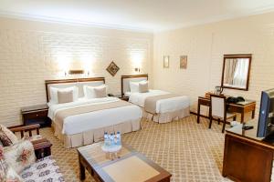 a hotel room with two beds and a tv at Hotel Grand Samarkand Superior - A in Samarkand