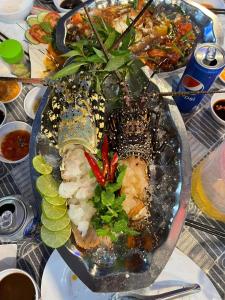 a plate of food with seafood and vegetables on a table at Nhà Nghỉ Phong Quỳnh - Đảo Phú Quý in Cu Lao Thu
