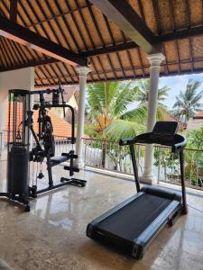 un gimnasio con dos máquinas de correr y una cinta de correr en Motama Villa en Ubud