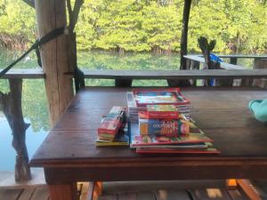 un montón de libros sentados en un banco de madera en Friend of Nature Bungalow en Koh Rong Island