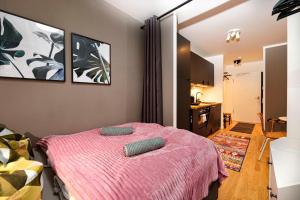 a bedroom with a pink bed with two pillows on it at Blue Chili 33 - Modernes & gemütliches Business Apartment am Airport BER in Schönefeld