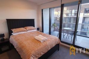 a bedroom with a bed and a large window at Lovely in Lyneham - 1bd 1bth Apt in Canberra