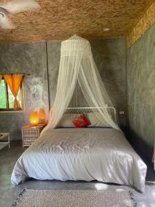 een slaapkamer met een bed met een klamboe bij Big hug home-Forest House in Ban Takhrai