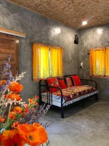 een bed met rode kussens in een kamer met bloemen bij Big hug home-Forest House in Ban Takhrai