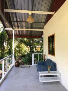 een veranda met een blauwe bank en een tafel bij Big hug home-Forest House in Ban Takhrai