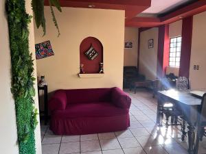 salon z czerwoną kanapą i stołem w obiekcie Apartamento Central Xelajú w mieście Quetzaltenango